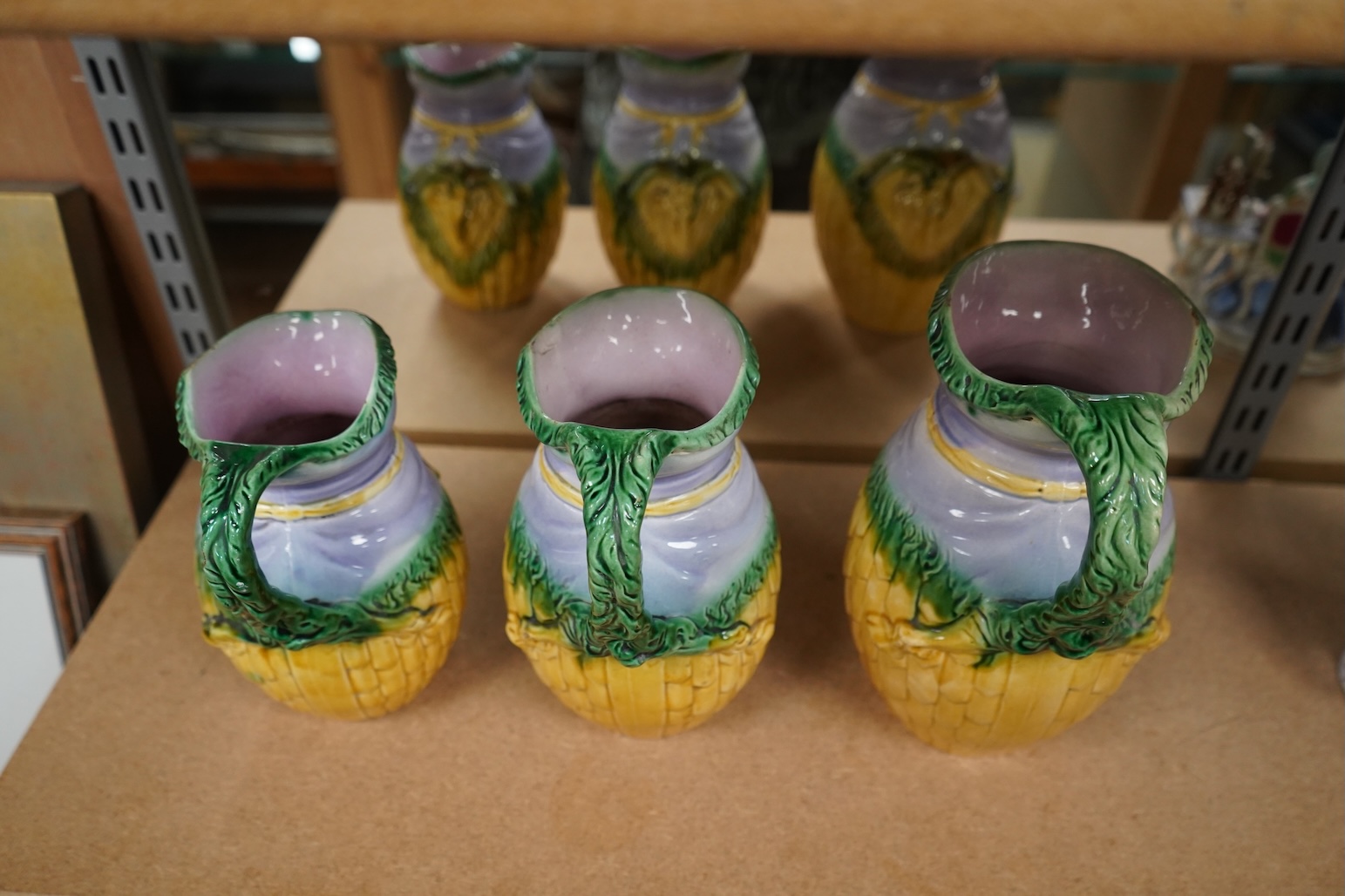 A graduated set of three maiolica ram decorated jugs, tallest 23cm high.